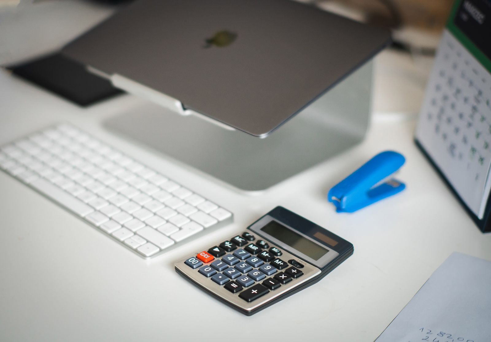 Modern desk with laptop, calculator, keyboard, and 2026 planner, representing financial planning at Simply Spreadsheets