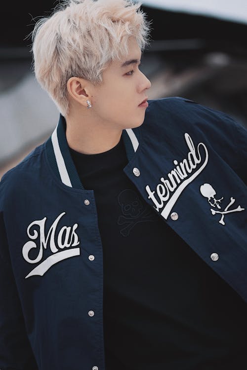 Young Man with Dyed Platinum Blond Hair Wearing a Baseball Jacket 