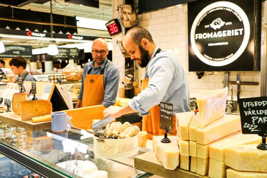 Cheese sellers at Fromageriet counter in Stockholm market.