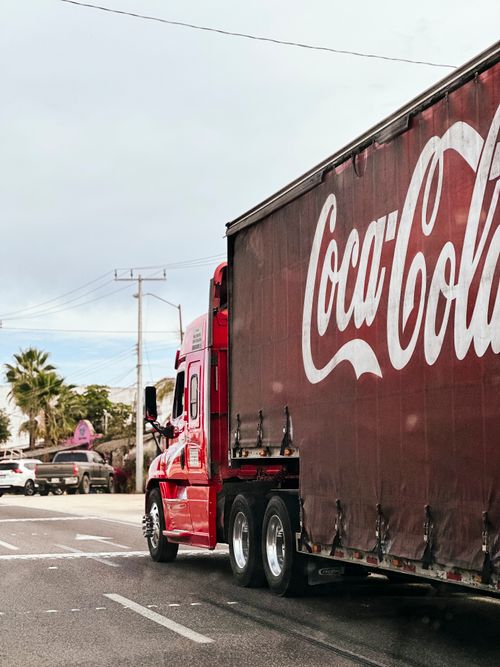 Free A red Coca Cola truck navigating a busy street in El Pescadero, Mexico. Stock Photo