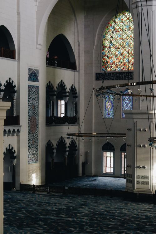 Free An elegant mosque interior showcasing intricate designs and vibrant stained glass windows. Stock Photo