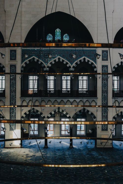 Free Vertical shot of a beautifully decorated traditional mosque interior with arched windows. Stock Photo