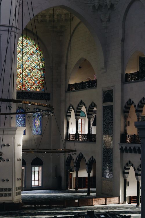 Free Majestic mosque interior showcasing intricate arches and colorful stained glass. Stock Photo