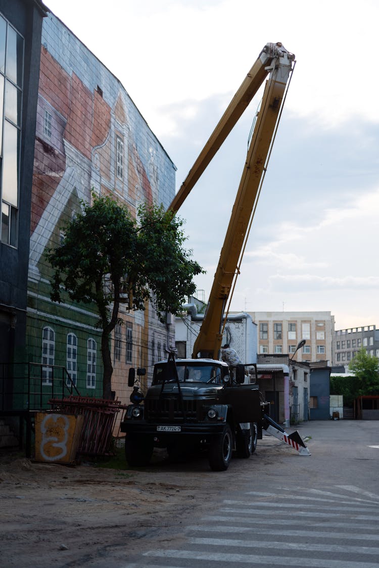 Truck With Boom Near Buildings