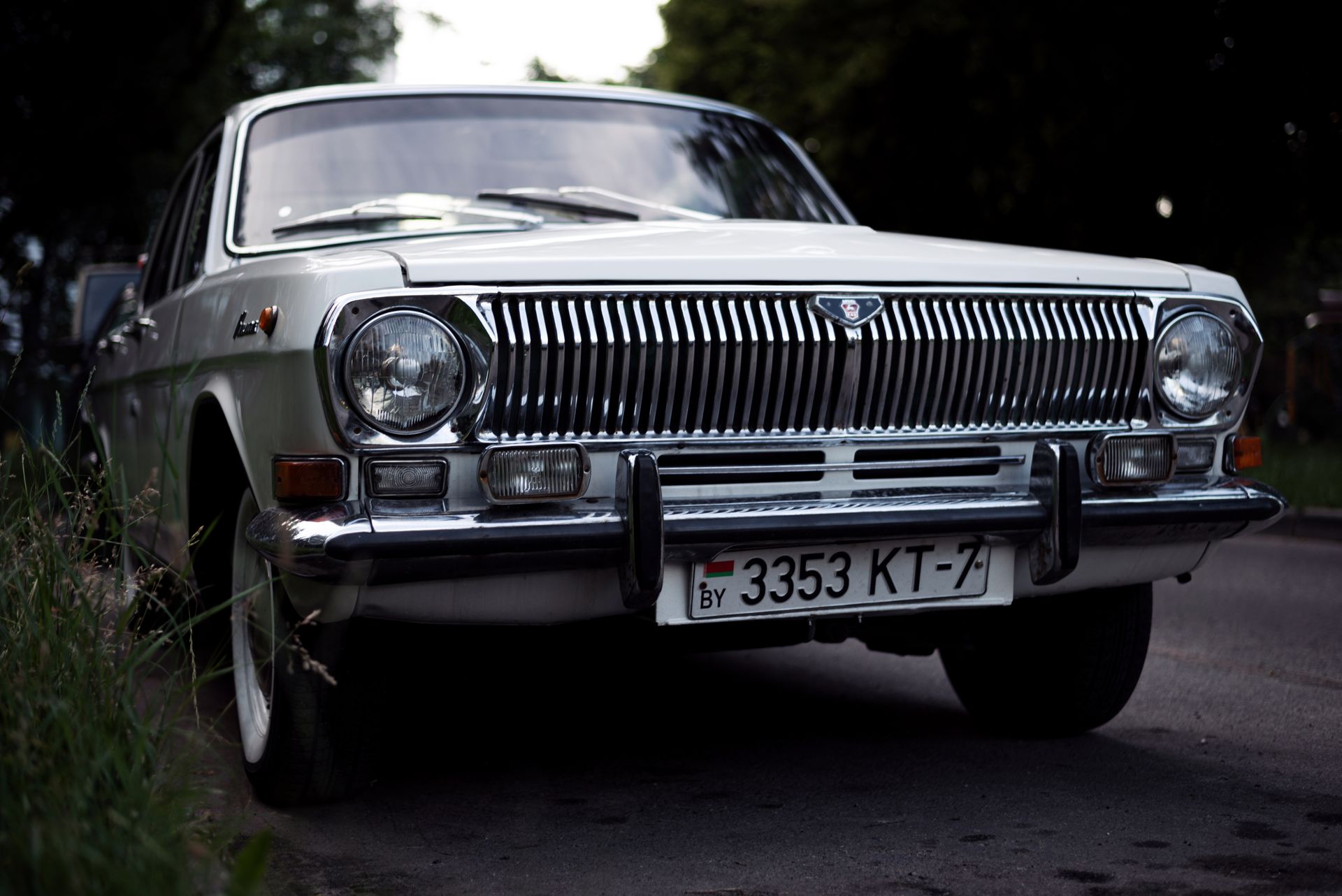 Front view of a classic Gaz-24 vintage car with a Belarusian license plate parked on a street.