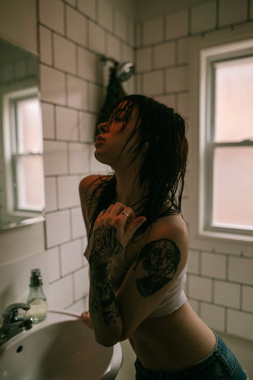 Woman with Tattoos Posing in Bathroom