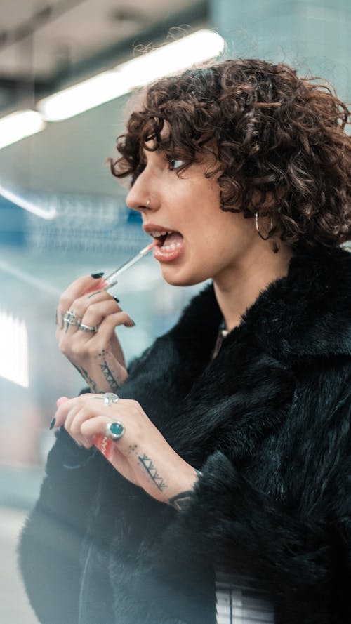 Brunette Woman Applying Lipstick