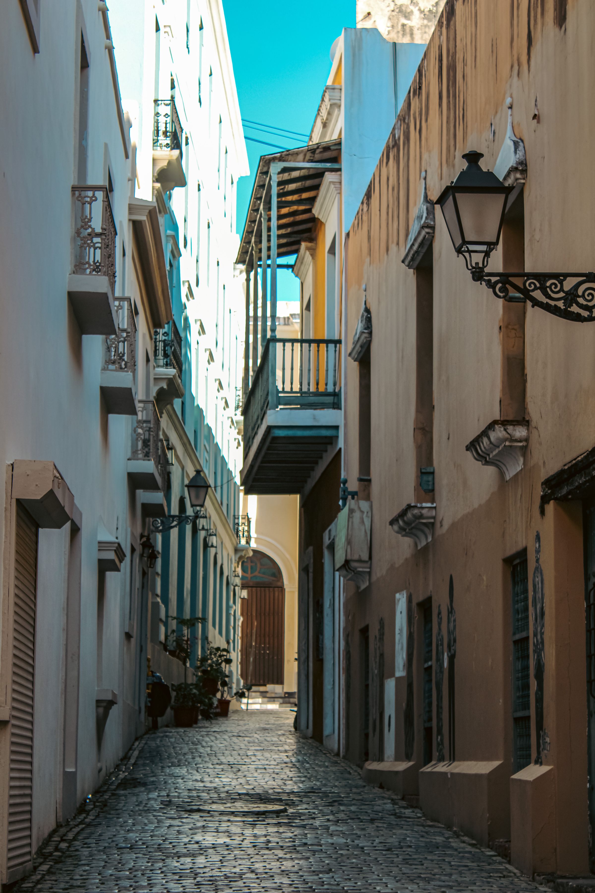 A lantern-lined cobblestone alley between historic buildings in Old San Juan
