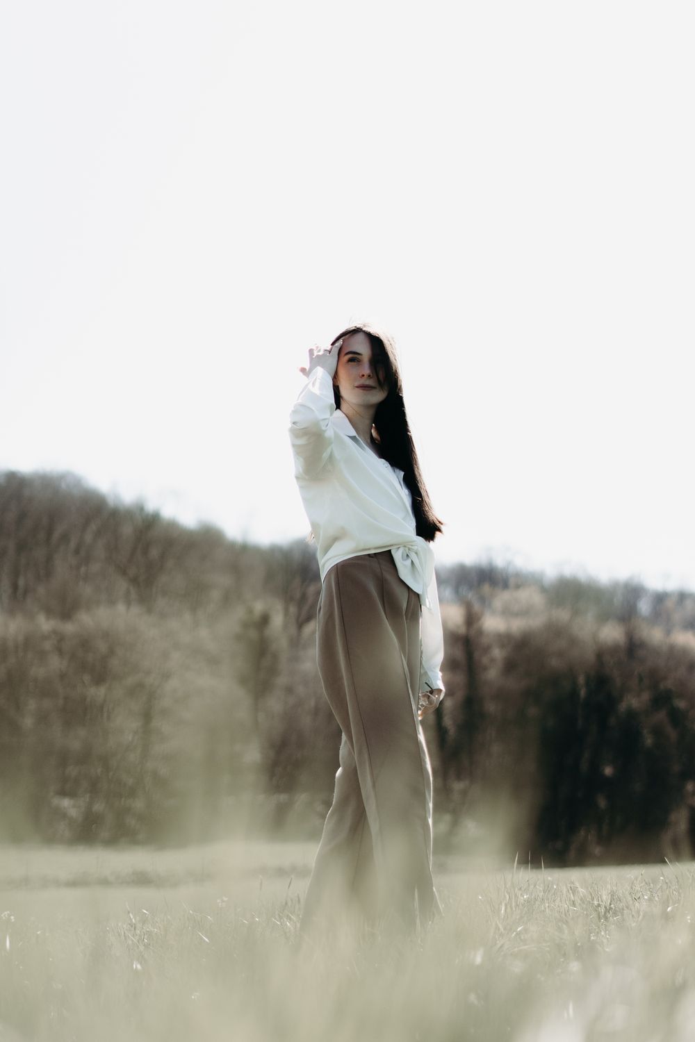 Helle Bluse und Hose in einem gedämpften Naturton auf einer Wiese