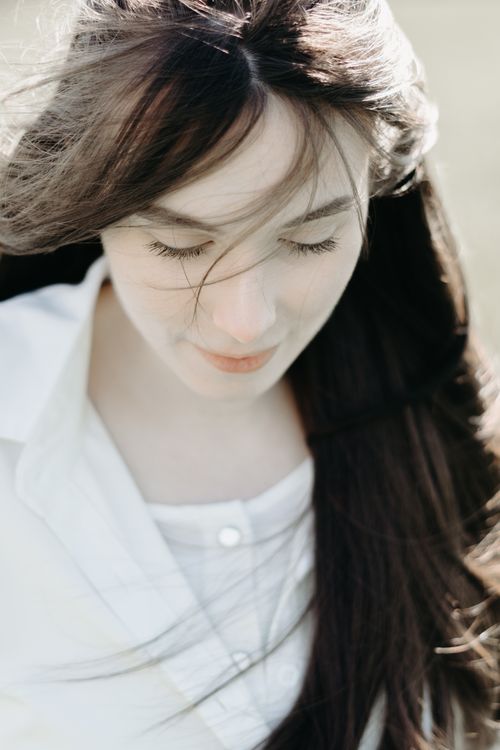 Free A serene outdoor portrait of a young woman with brunette hair in Andenne, Belgium. Stock Photo