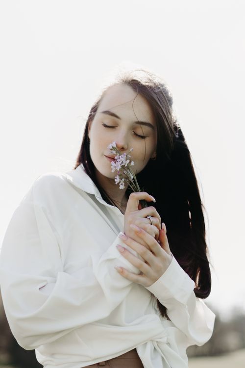 Free Serene portrait of a woman in Andenne, savoring the scent of spring flowers in a tranquil outdoor setting. Stock Photo