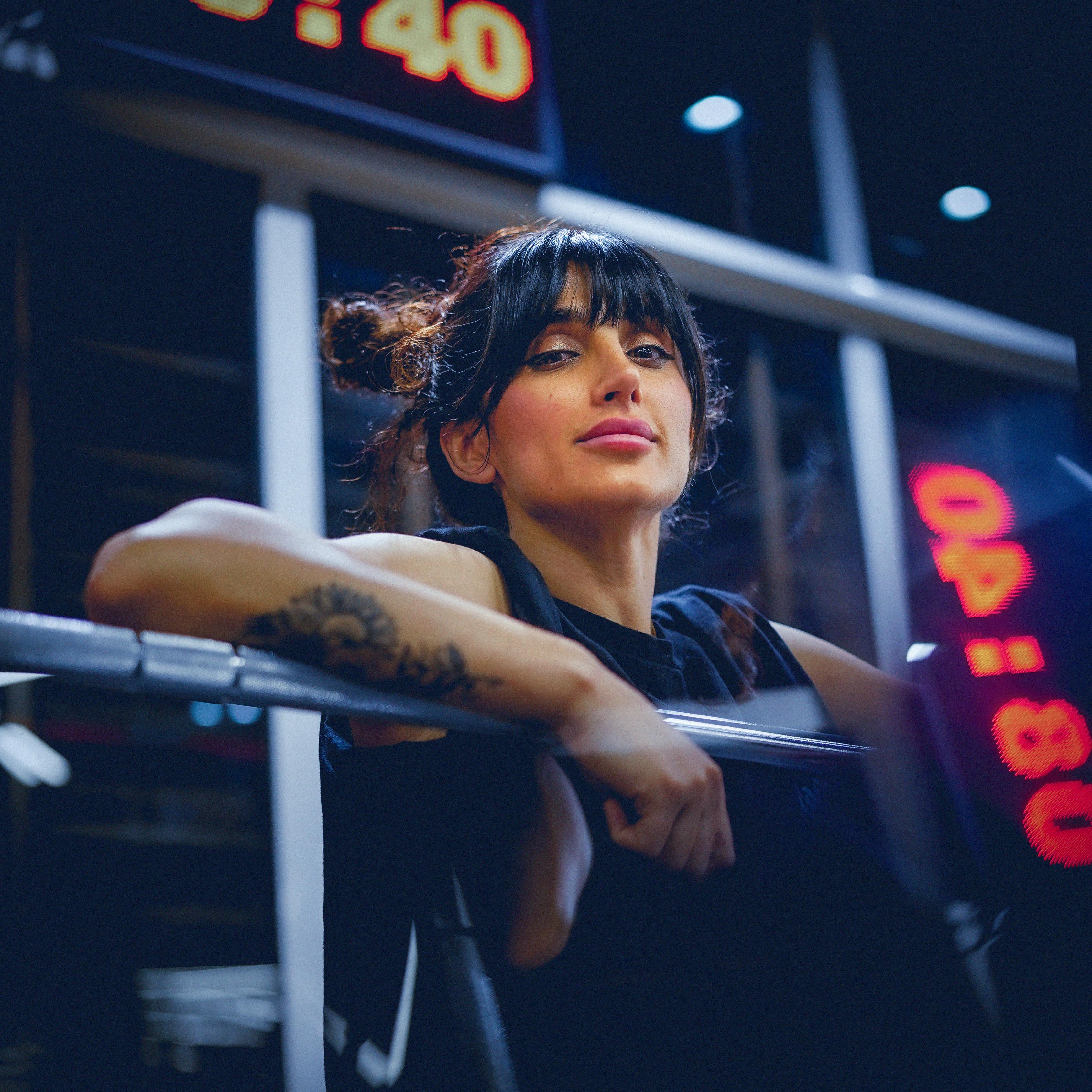 a woman with tattoos on her arm is sitting on a bench