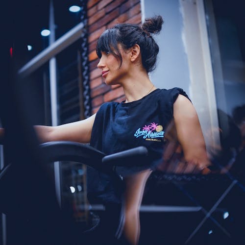 A woman in a black shirt riding a stationary bike