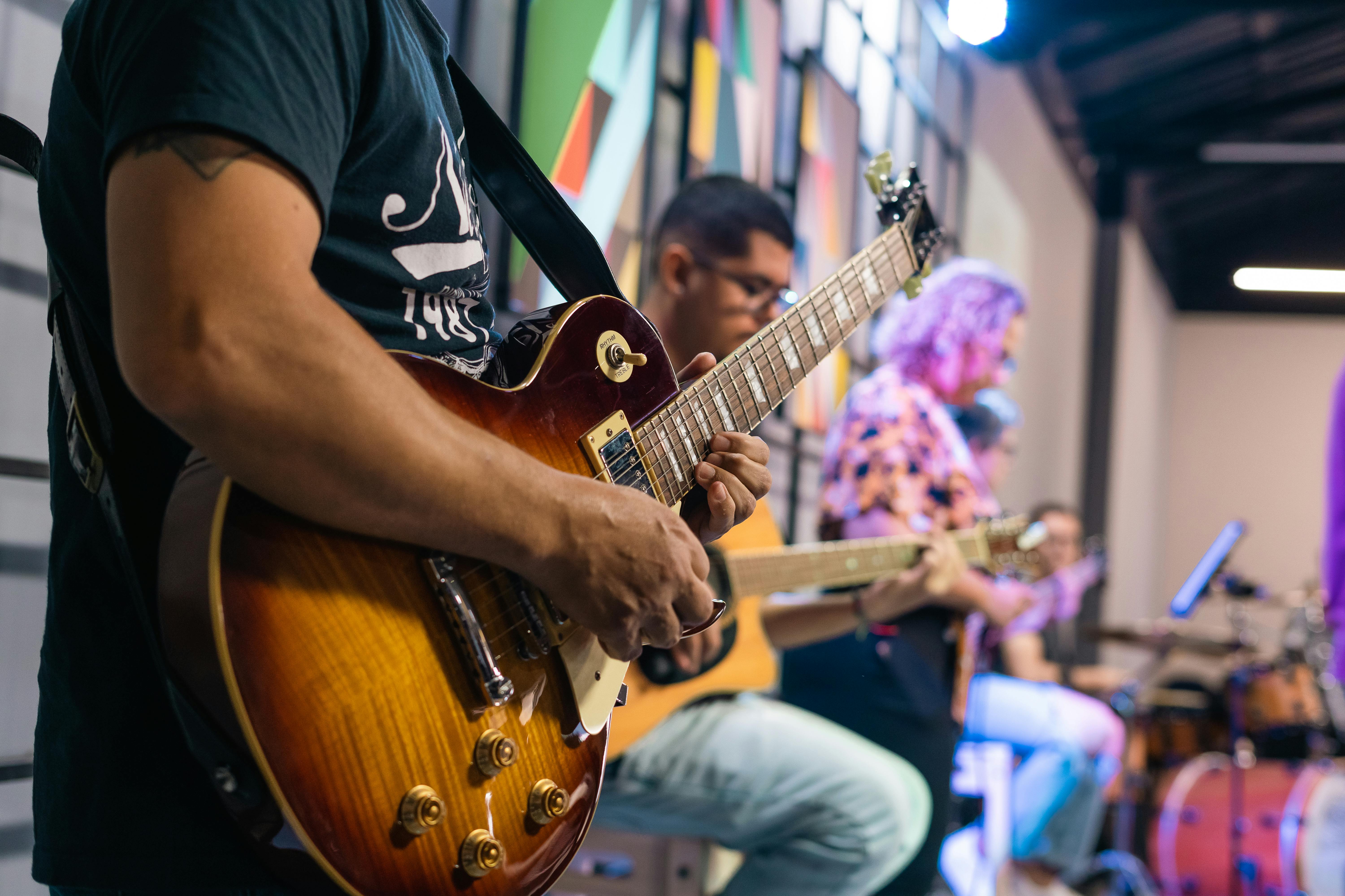 Group of young musicians jamming together with guitars and drums in a church hall in Ho