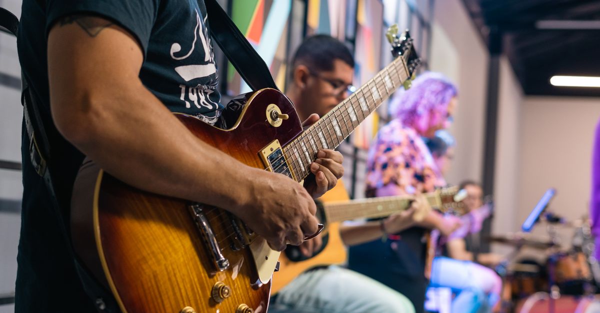 Group of young musicians jamming together with guitars and drums in a church hall in Ho