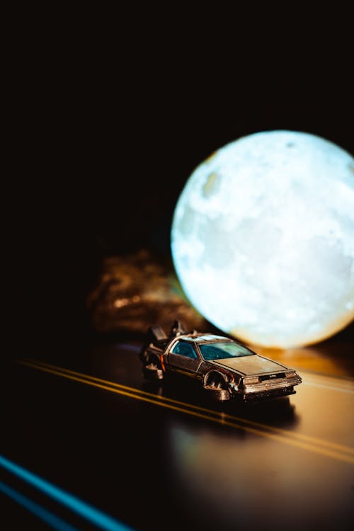 Flying DeLorean Time Machine from Back to the Future Next to a Full Moon Lamp