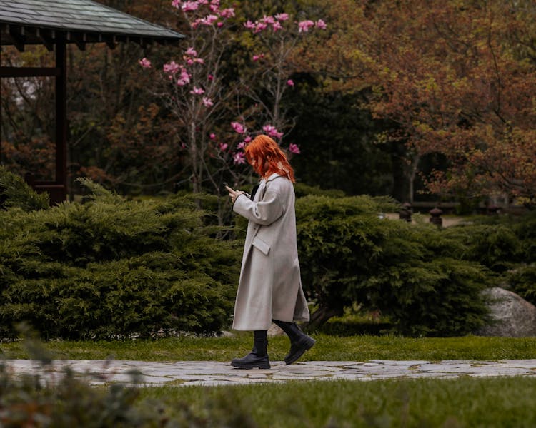 Woman In Coat Walking In Park