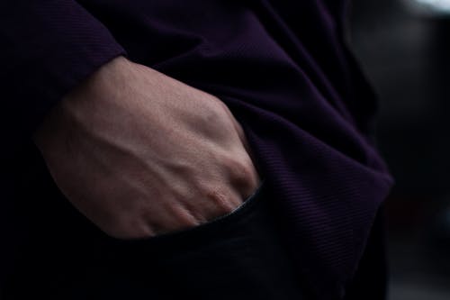 A person wearing a purple shirt and black pants