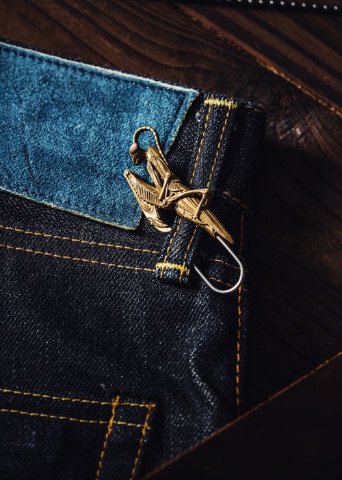 Free Vintage brooch on denim jeans pocket, capturing modern fashion style with unique decoration. Stock Photo