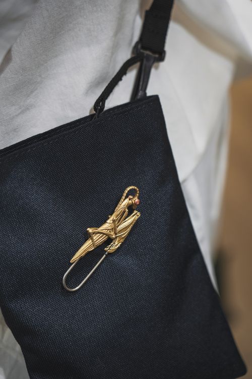 Free Stylish golden brooch on a black bag, offering a chic decorative touch. Stock Photo