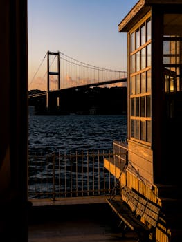 Stunning view of the Bosphorus Bridge at sunrise, seen from a waterside location in Istanbul.