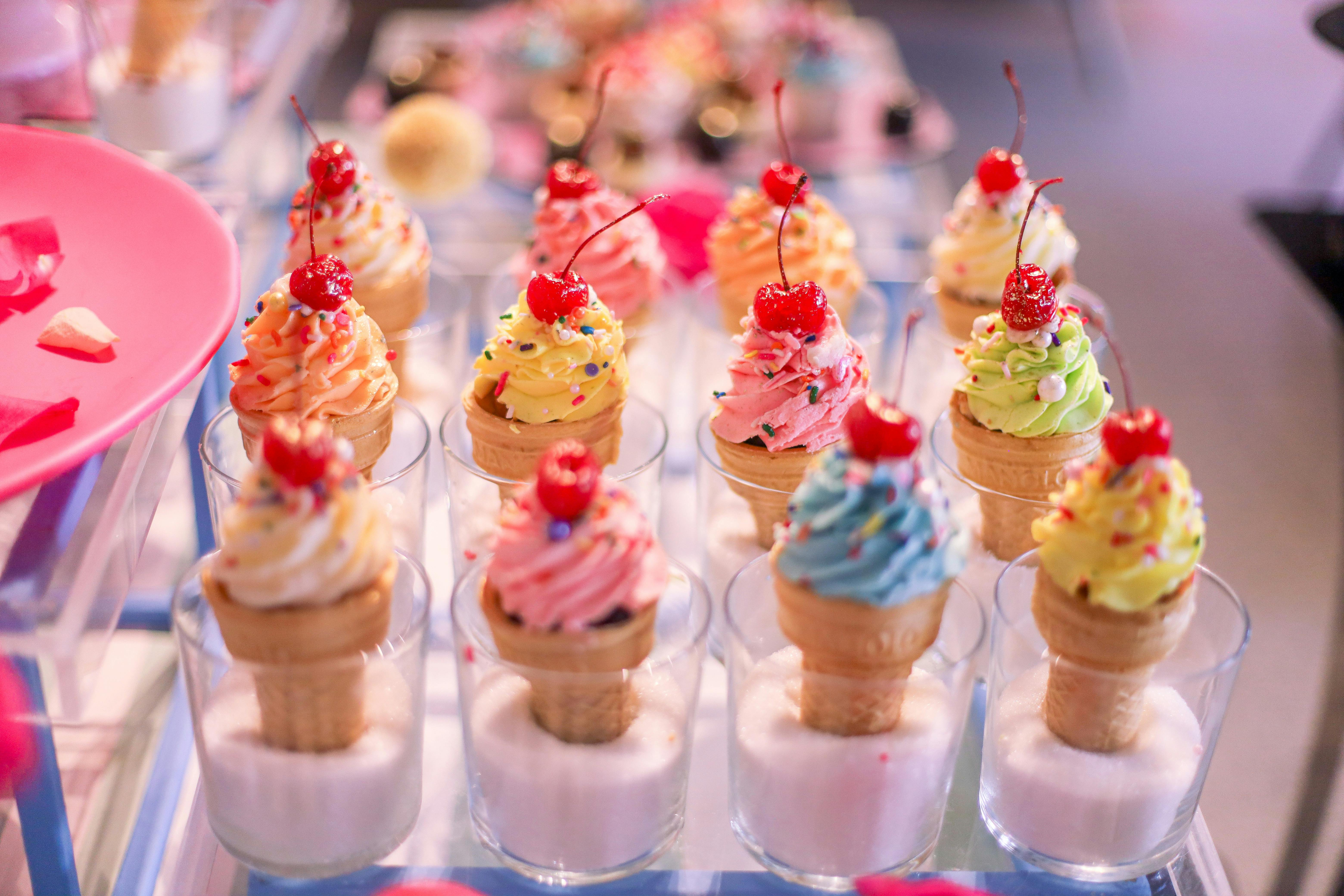 Different flavours ice cream cone with red cherry on top