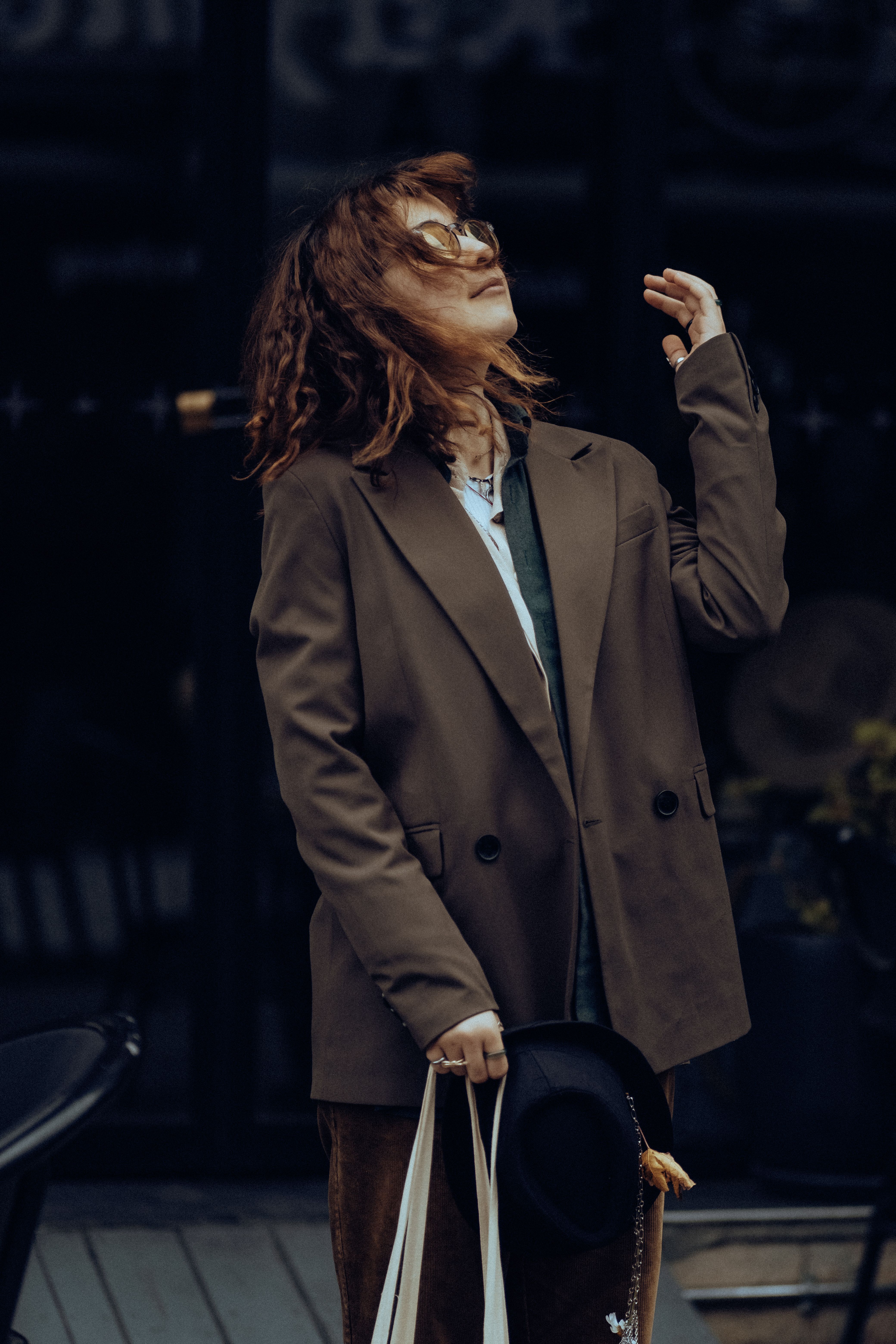 Young Woman Wearing a Brown Blazer and Holding a Hat in Hand · Free ...