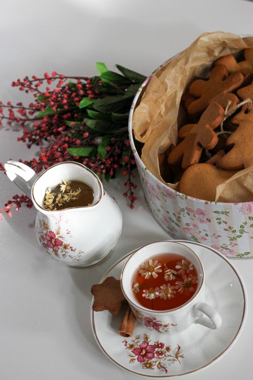 Free A cozy tea time setup with floral porcelain cup and gingerbread cookies. Stock Photo