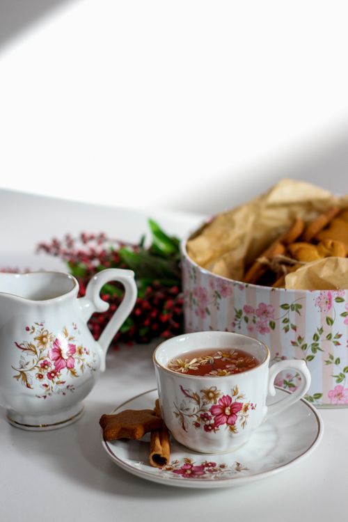 Free Elegant floral tea set with cinnamon rolls and decorative pitcher, perfect for afternoon tea scenes. Stock Photo