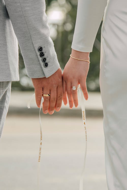 Man and Woman Holding Hands on Wedding Day