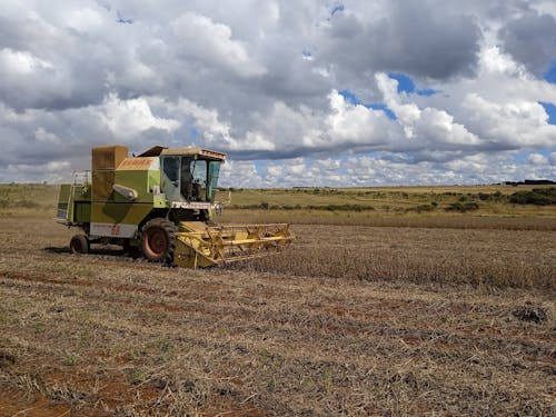 Harvester on Field under Clouds