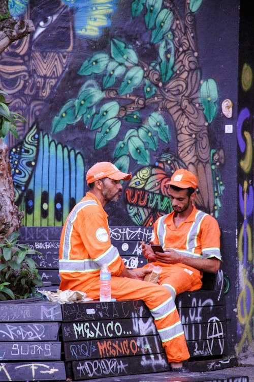 Workers Sitting by Wall with Mural