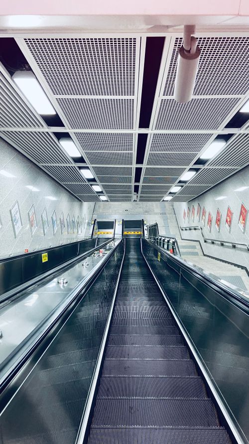Free Explore the sleek design of a modern subway escalator with no people in sight, offering a unique architectural perspective. Stock Photo
