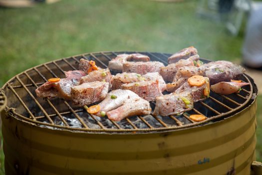 Fresh fish and vegetables grilling on a barbecue outdoors, showcasing a delicious summer meal.