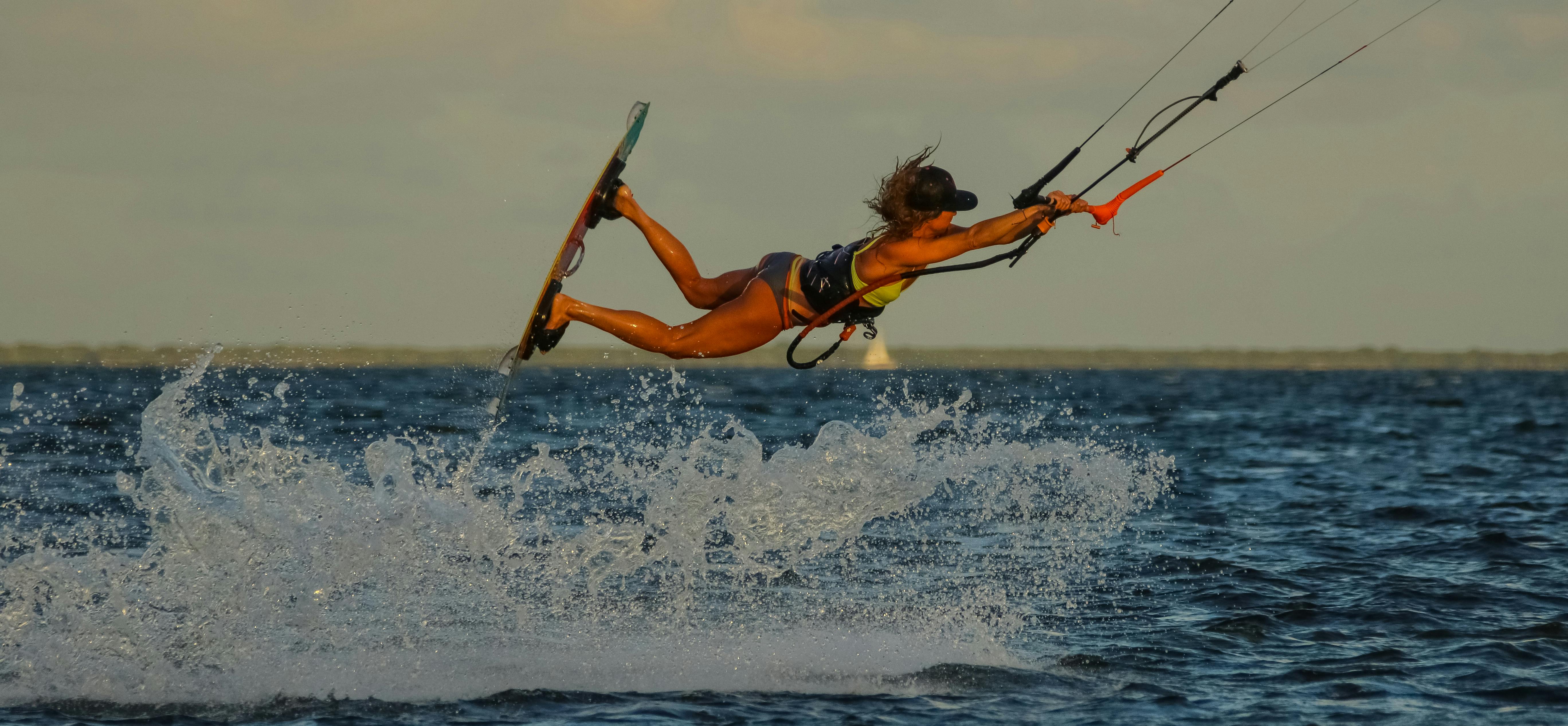 在充满活力的夏季环境中，海上捕捉到的风筝冲浪动作展示了激动人心的技巧