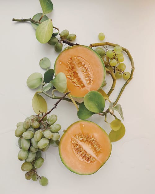 gratis Twee Gesneden Meloenen En Druiven Stockfoto