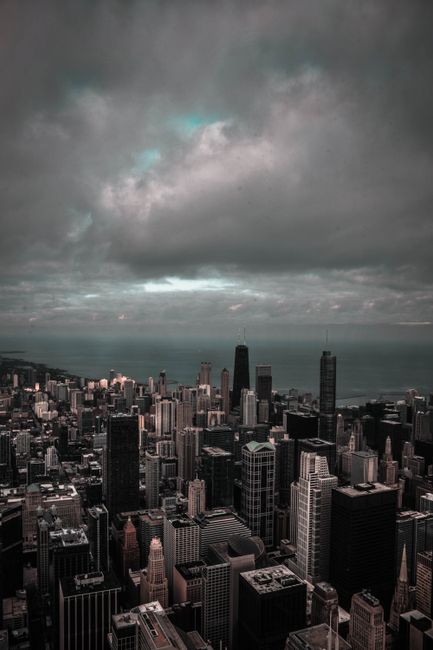A moody cityscape with skyscrapers under a dramatic, cloudy sky, perfect for urban themes.