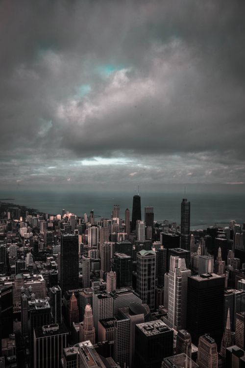 Free A moody cityscape with skyscrapers under a dramatic, cloudy sky, perfect for urban themes. Stock Photo