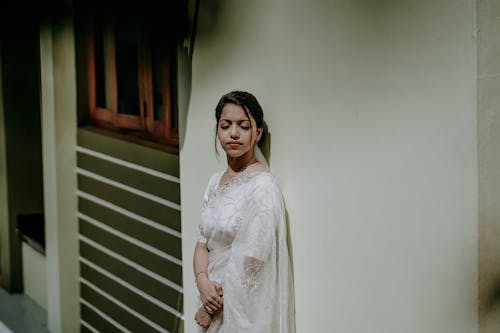 Woman in a White Dress Leaning Against the Wall