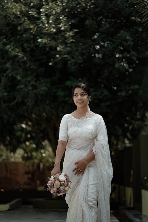 Young Woman in a White Sari with a Bouquet of Flowers