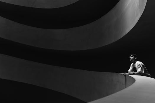 Minimalist black and white photo of a man in modern architecture.