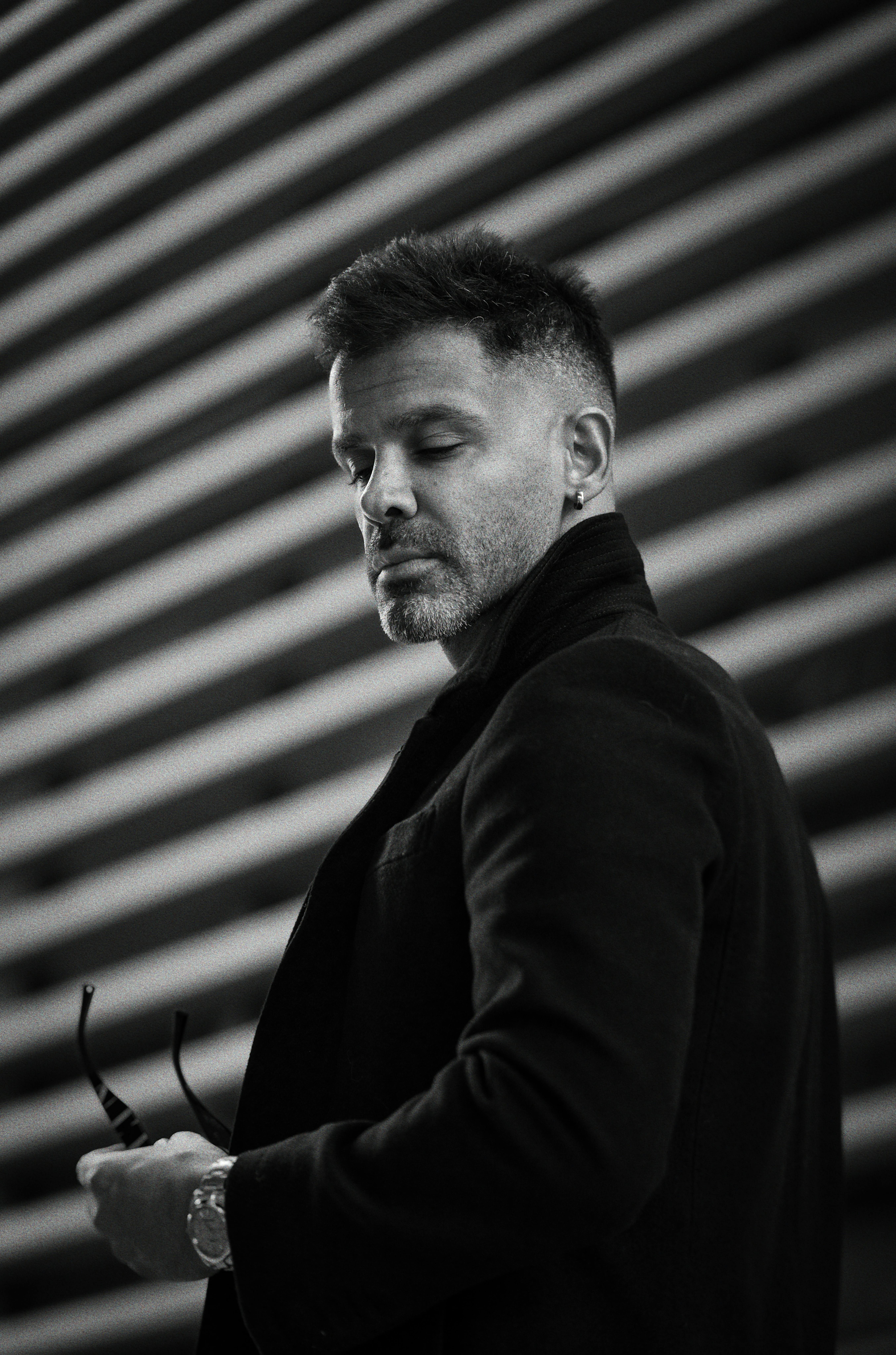 Black and white portrait of a stylish man with sunglasses in urban background.
