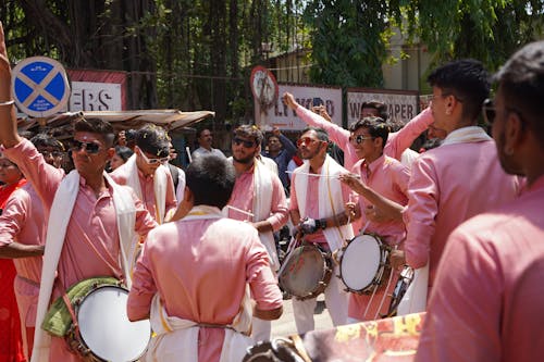 Male Orchestra in Pink Outfits Playing the Drums at a Parade 