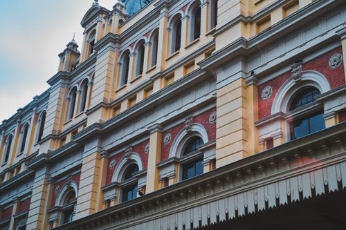 Free A detailed view of an ornamented historic building facade with arches and windows. Stock Photo