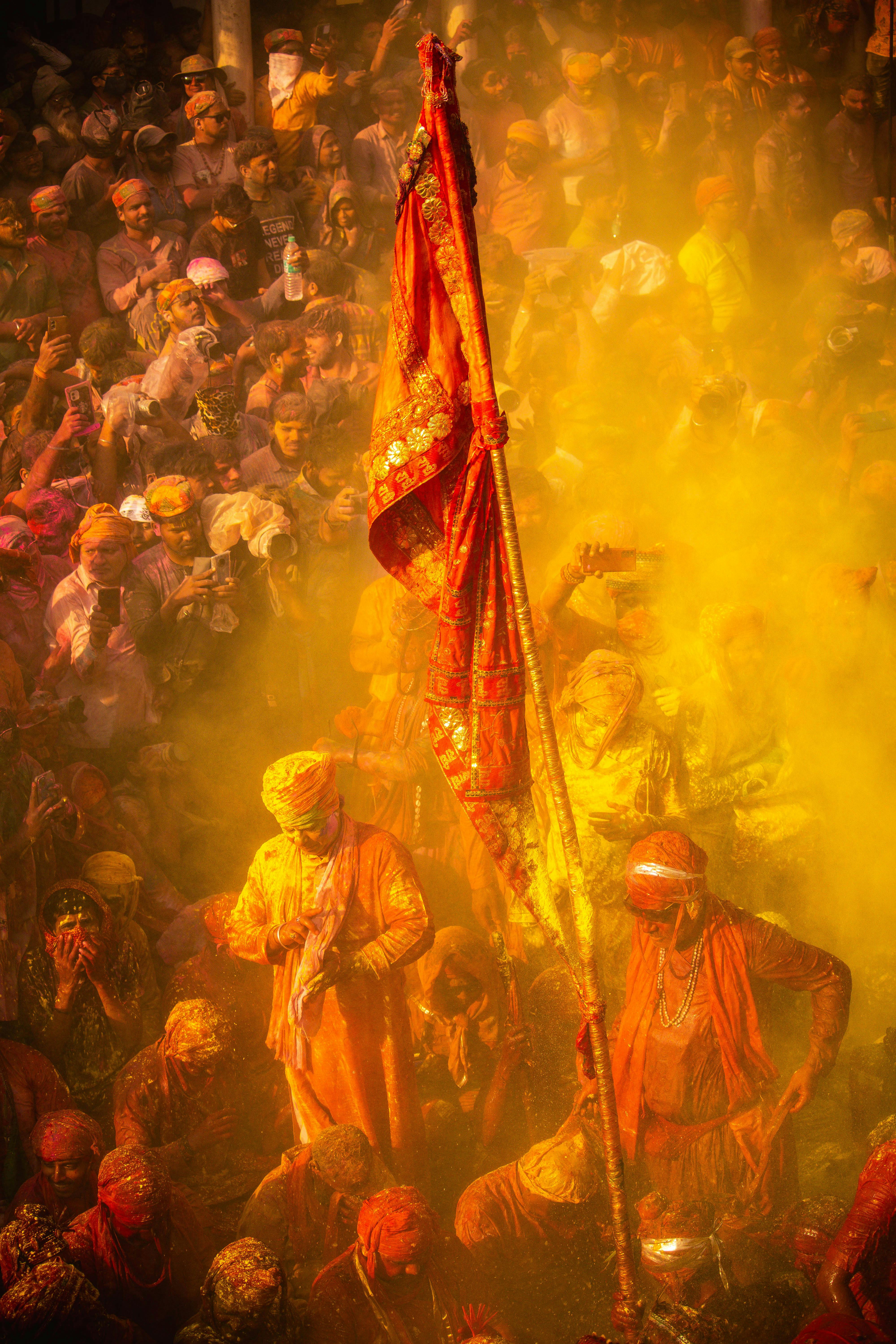 Colorful Holi festival scene in Vrindavan, Uttar Pradesh, India with people celebrating amidst vivid powders.