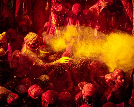 Colorful Holi festivities in Vrindavan with people joyfully throwing vibrant powders.