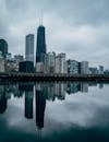 阴云密布的天空下，芝加哥天际线的美景倒映在平静的河流中