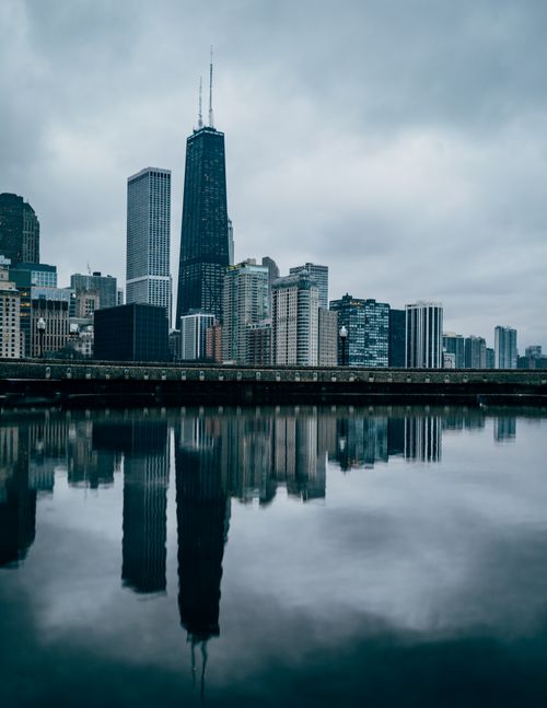 Free Scenic view of Chicago skyline mirrored in a calm river under overcast skies. Stock Photo