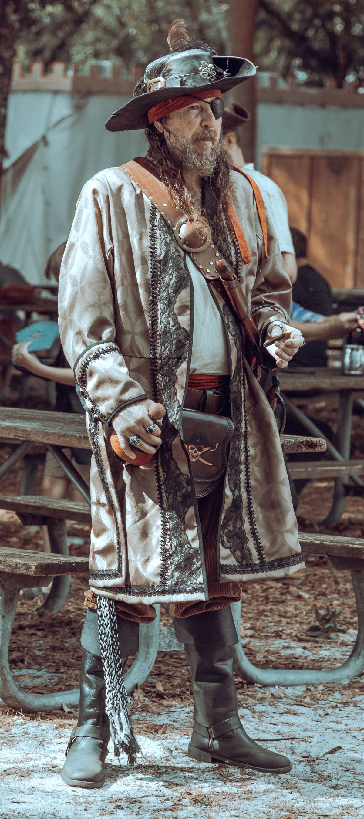 Hombre vestido de pirata con abrigo y sombrero en un festival temático
