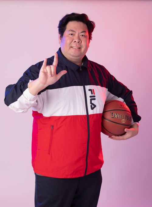 Free Portrait of a confident man with a basketball making a hand sign in a studio setting. Stock Photo